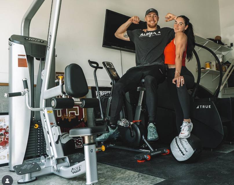 George kittle with his wife in his home gym 